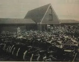 Zwart-witbeeld van het gebouw van De Koemen met een groot aantal geparkeerde fietsen ervoor.
